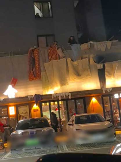 烧烤店油烟熏天！楼上老人门头挂被褥抗议引热议